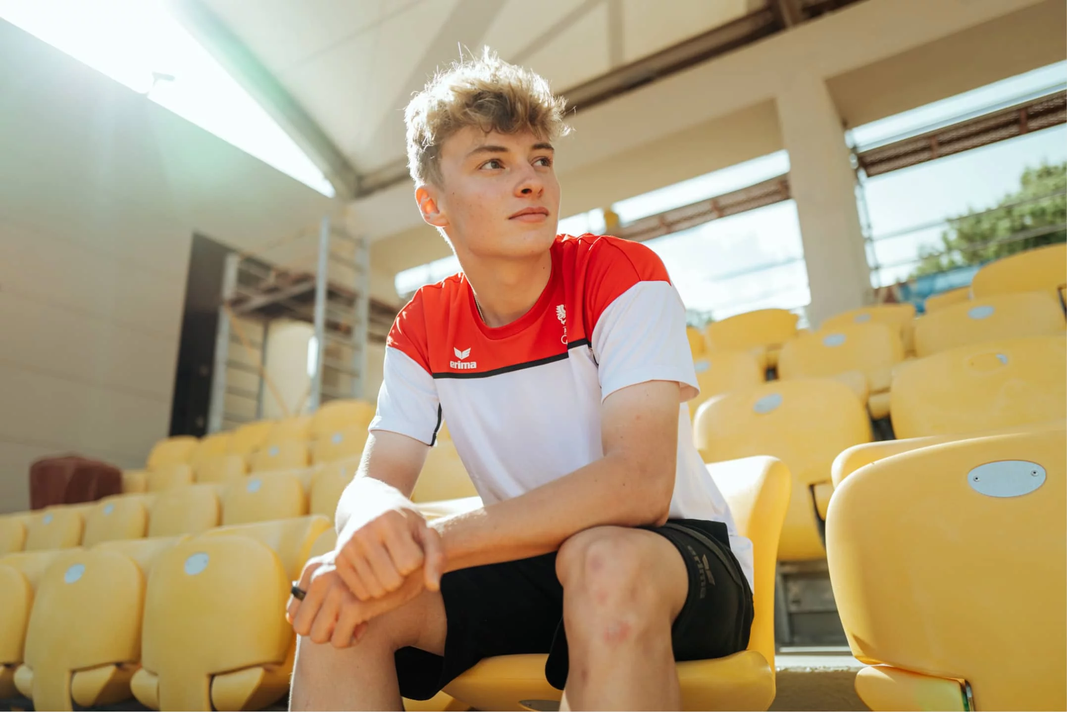 Mentorin feuert lächelnd ein junges Basketballtalent beim Dribbling in einer Sporthalle an